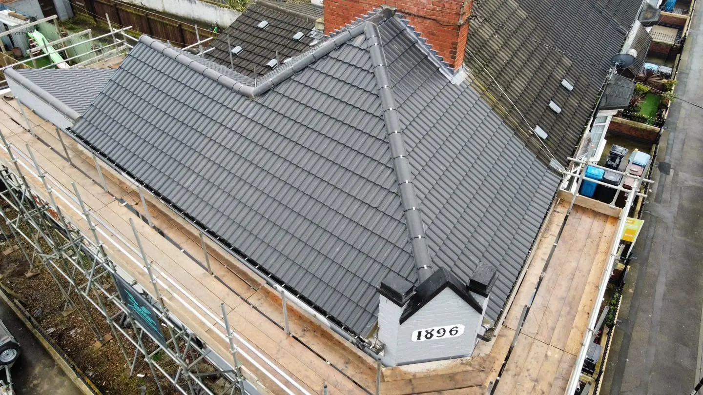 Grey tiled hipped roof seen from above after replacement