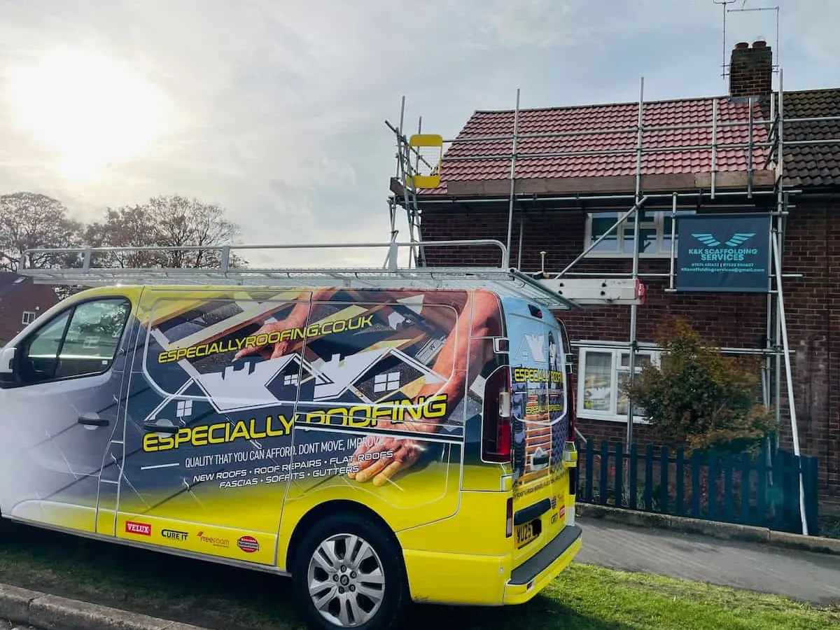 Especially Roofing van parked beside a house under scaffolding for a re-roof