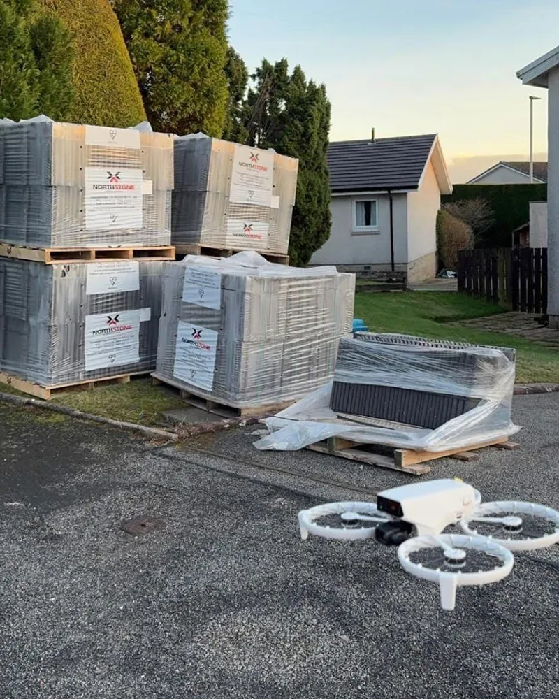 Inspection drone beside pallets of new roof tiles