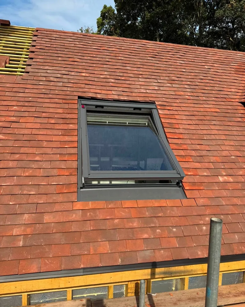 Roof window fitted in red plain tiles