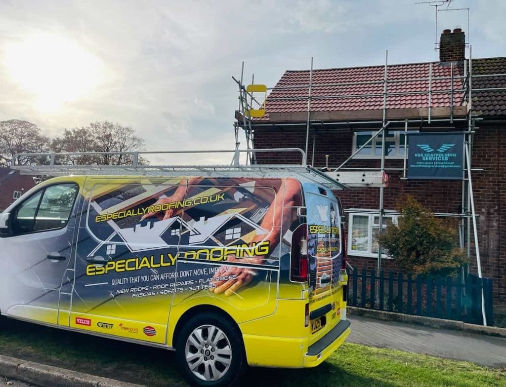 A yellow and white Especially Roofing van is parked outside a brick house with scaffolding set up for roof repairs. A sign for KA Services Roofing is visible on the scaffolding.